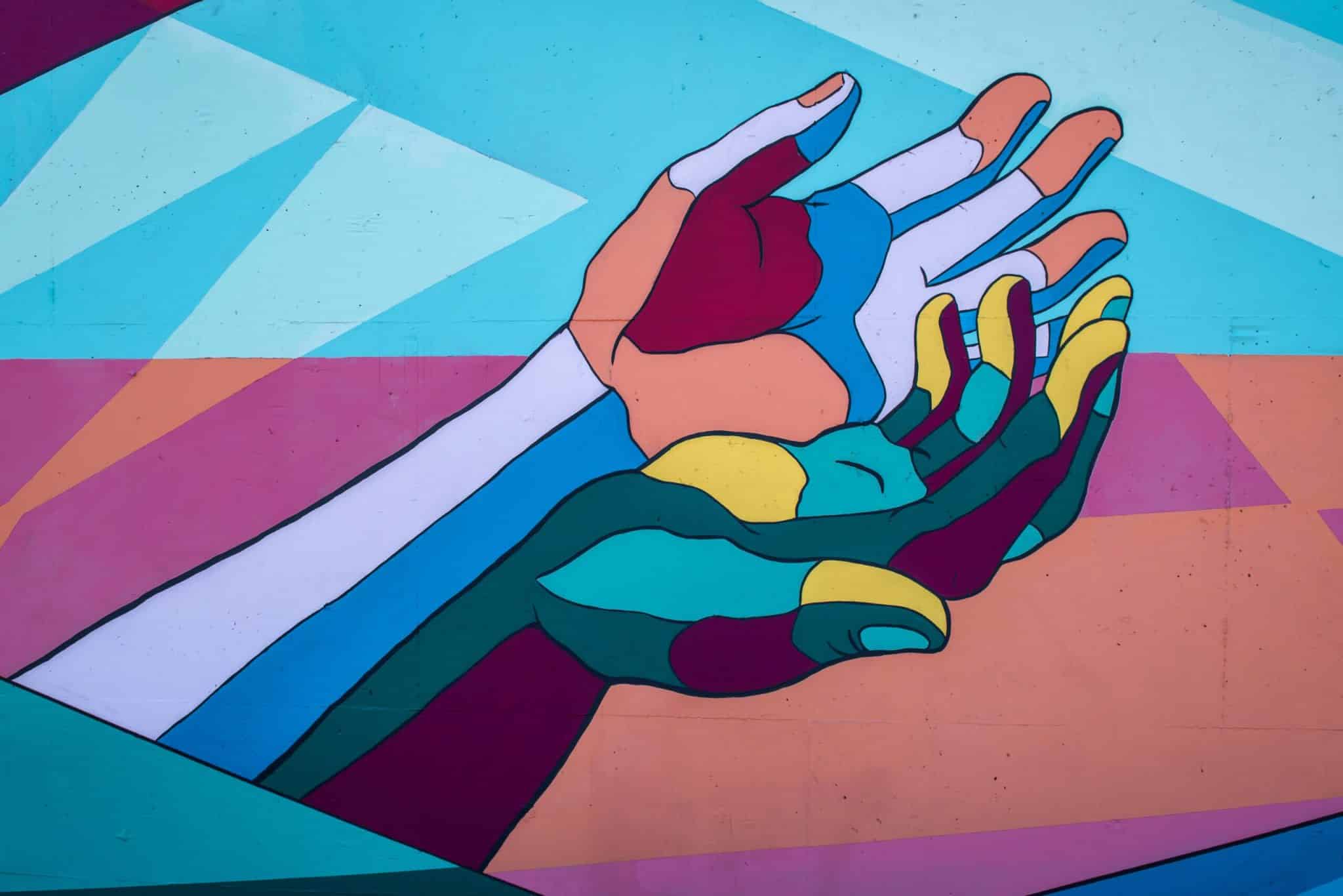 Photo of colorful mural with two hands by Tim Mossholder for Unsplash